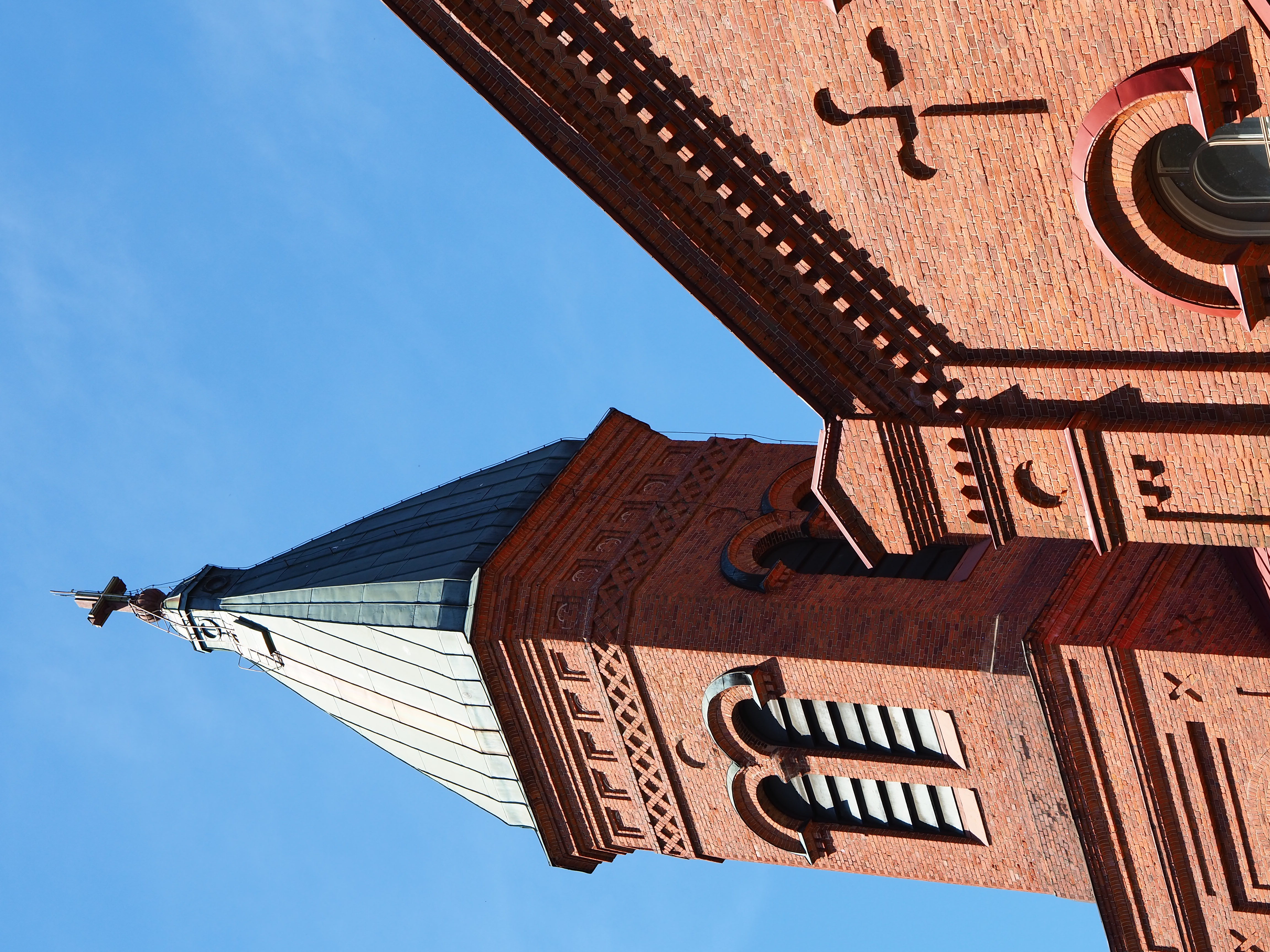 Kuvassa Lopen kirkon torni ja sininen taivas